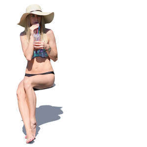 woman in a bikini sitting and drinking cocktail