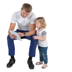 father sitting and looking at tablet with his daughter