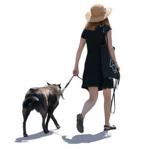 backlit woman walking a dog