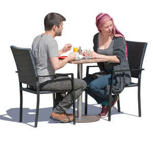 man and woman sitting in a street cafe