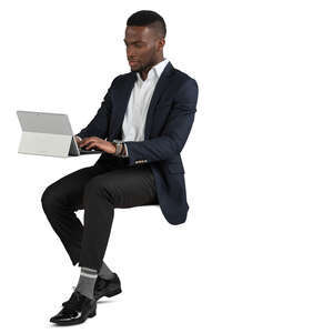 black man sitting and working with laptop