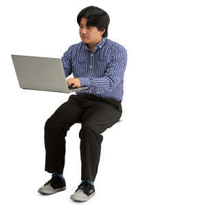 asian man sittinf behind a desk with laptop