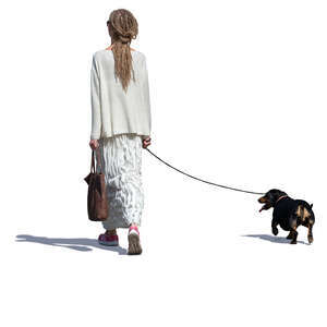 woman in a long white dress walking a dog