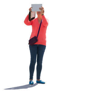 backlit woman taking a picture with a tablet