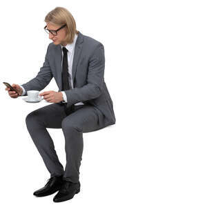 man in a suit drinking coffee in a cafe