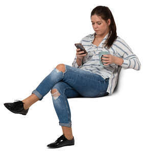 woman with a coffee mug sitting and texting