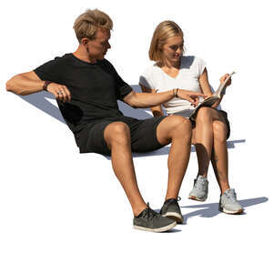 man and woman sitting on a bench and reading a magazine