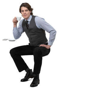 man in a tie and vest sitting in a cafe