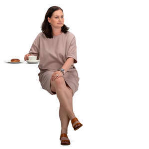 woman in a beige dress sitting in a cafe