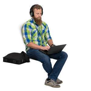 man with headphones sitting and working with laptop