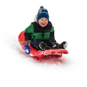 happy little boy sledging down the hill