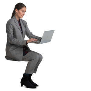 woman in a grey costume sitting and working with laptop