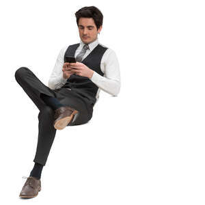 man in a formal suit vest sitting and texting