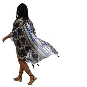 black woman in a beach kaftan walking