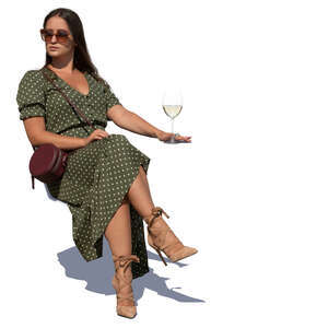 woman sitting in an outdoor cafe and drinking white wine