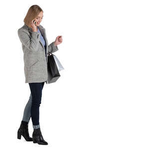 woman with shopping bags standing and talking on a phone