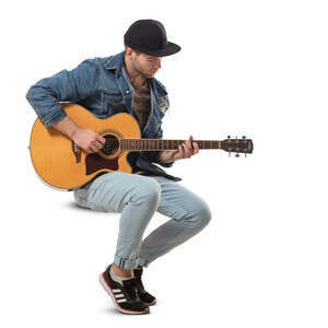 man sitting and playing a guitar