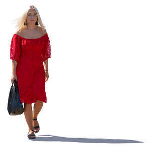 backlit woman in a red dress walking