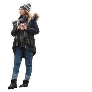 woman in a winter coat standing on a balcony and drinking coffee