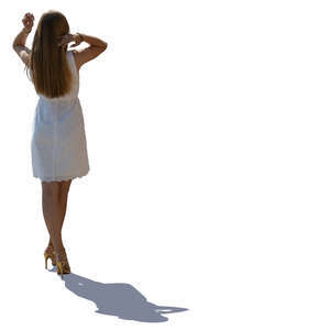 backlit woman in a white dress standing