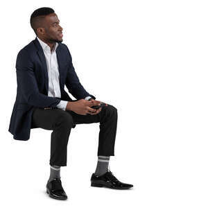 black man in a suit sitting on a chair