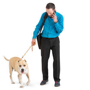 man with a dog standing and talking on a phone