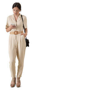 cut out woman in a beige jumpsuit standing and checking her phone