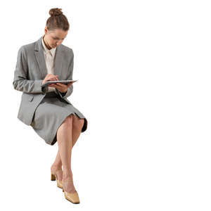 cut out young businesswoman sitting and looking at her tablet