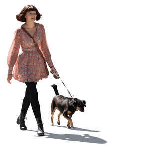 cut out young backlit woman walking a dog