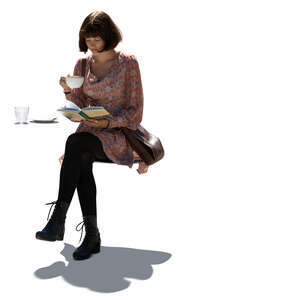 cut out young woman sitting in a cafe and readin a book