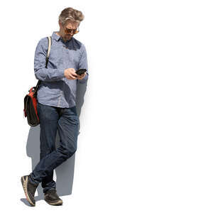 cut out man standing and leaning against the wall and checking his phone