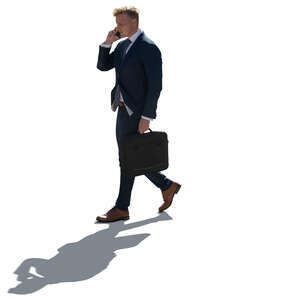 cut out backlit businessman walking and talking on a phone