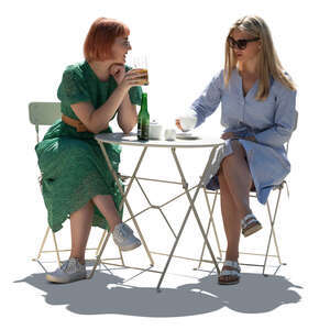 two cut out backlit young women sitting in a cafe and talking