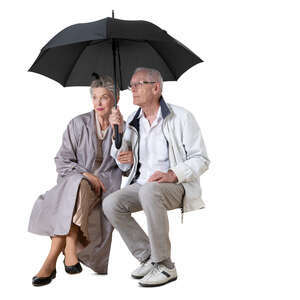 cut out elderly couple sitting together under an umbrella