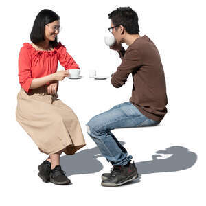 cut out asian man and woman sitting in a cafe and drinking coffee