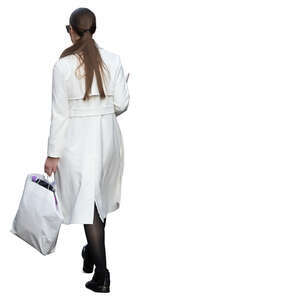 woman in a white overcoat walking with shopping bag in her hand