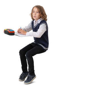 cut out schoolboy sitting at a desk and writing