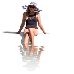 cut out woman sitting at the edge of the pool with her legs in the water