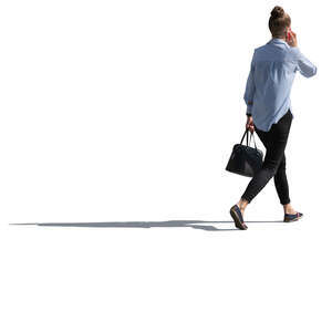 backlit woman walking and talking on the phone