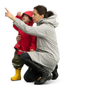 cut out woman with small child squatting and pointing at smth