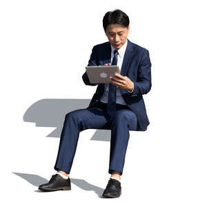 cut out asian  businessman sitting and working with tablet