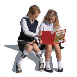 two cut out girls sitting and reading a book