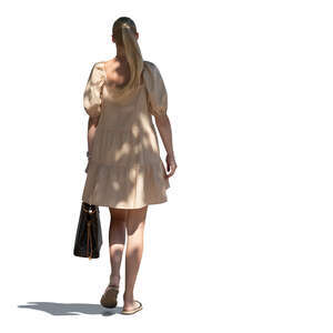 cut out young woman in a summer dress walking in a tree shade