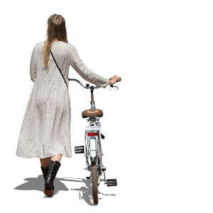 cut out woman in a long summer dress walking and pushing a bike