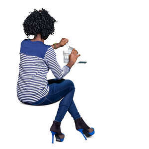 cut out black woman sitting at a table and drinking water