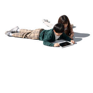 two cut out asian kids lying on the floor and looking at a tablet