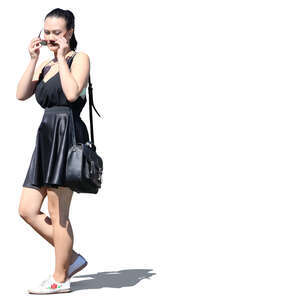 young asian woman in a black summer dress walking