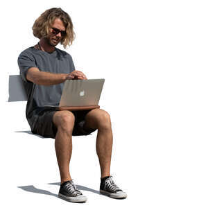 man sitting with a laptop on his knees