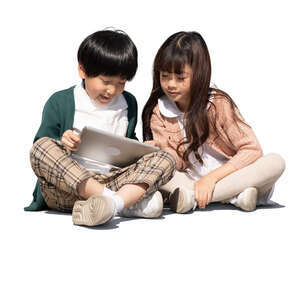 two cut out asian kids sitting and watching their ipad