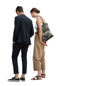 young man and woman standing and looking something on a table